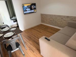 a small living room with a table and a couch at Azores Pedra Apartaments A in Fajã de Baixo