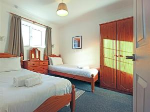 a bedroom with two beds and a dresser at Tom Putt in Ledbury