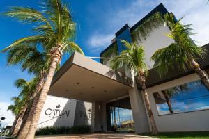 ein Gebäude mit Palmen davor in der Unterkunft Catuai Hotel Cacoal in Cacoal