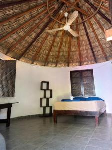 a bedroom with a bed in a straw roof at Shalom Backpacker Hostel in Puerto Escondido