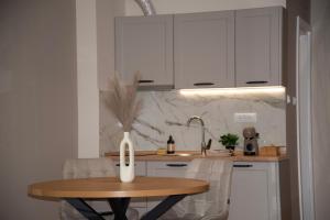 a kitchen with a wooden table and a sink at PANTEX Centar Zlatibor in Zlatibor +5 photos