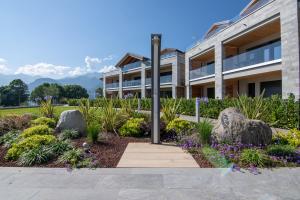 a building with a garden with flowers and rocks at Lago Dorato Townhouse Sabrina by the Como lake in Colico