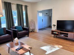 a living room with a flat screen tv and furniture at Kenoza House with Private Lake and Kayaks in Callicoon
