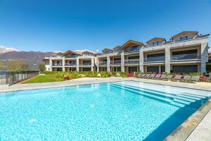 a large swimming pool in front of a building at Lago Dorato Townhouse Sabrina by the Como lake in Colico