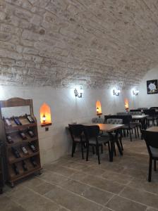 a restaurant with tables and chairs and a stone wall at Babilyon Otel in Urfa