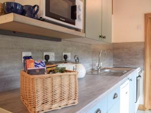 a kitchen counter with a sink and a microwave at Gooses Roost - Uk32096 in Dorstone