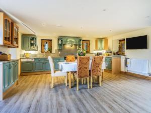 a kitchen with green cabinets and a table and chairs at Horsecroft - Uk37462 in Dorstone