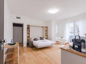 a white bedroom with a bed and a table at GINO SUITES - Monolocali Luxury - Appartamenti vicini a Rho Fiera e Milano in Bollate
