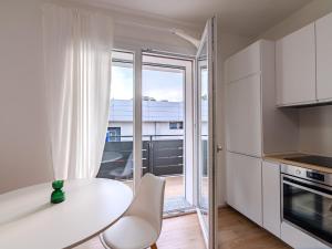 a kitchen with a white table and a balcony at GINO SUITES - Monolocali Luxury - Appartamenti vicini a Rho Fiera e Milano in Bollate