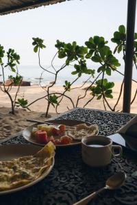 a table with a plate of food and a cup of coffee at Dwarka Beach Resort Goa in Cola +57 photos