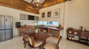 a kitchen with a wooden table and a refrigerator at Villa Monroe - Elegant Private Pool Villa in Ban Nok