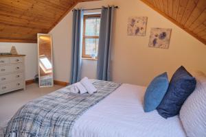 a bedroom with a bed with blue pillows and a window at 5 Bedroom House By Travel Lets Holiday Homes Donegal With Sweeping Lake & Hill Views in Carrigart