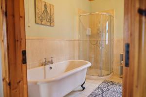 a bathroom with a bath tub and a shower at 5 Bedroom House By Travel Lets Holiday Homes Donegal With Sweeping Lake & Hill Views in Carrigart +59 photos