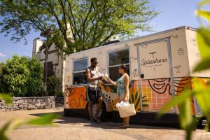 a man and woman standing in front of a food truck at Eden Resort and Suites, BW Premier Collection in Lancaster