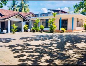 a house with palm trees in front of it at GMW Sanduni hotel & villa in Matara