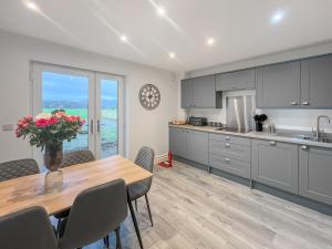 a kitchen with a table with a vase of flowers on it at Eriska View in Port Appin