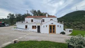 a white house with a hill in the background at Quinta Cabecinha in Penela