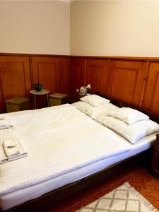 a bedroom with a large bed with a wooden headboard at Muskátli Panzió és Étterem in Újhartyán