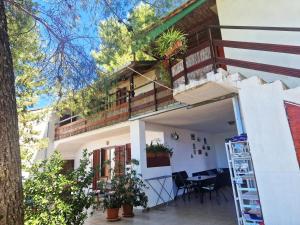a house with a balcony and a table on the porch at Apartments Vera - Mirca in Mirce