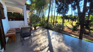 a patio with a table and chairs and trees at Apartments Vera - Mirca in Mirce
