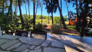 a patio with a table and benches and trees at Apartments Vera - Mirca in Mirce