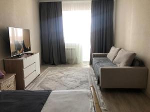 a room with a bed and a couch and a window at ЖК 'Арман ' in Aktobe