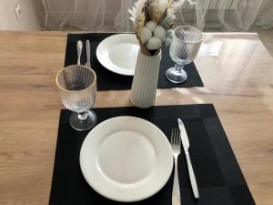 a table with two white plates and a vase with flowers at ЖК 'Арман ' in Aktobe