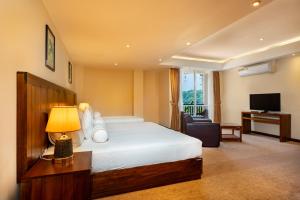 a hotel room with a bed and a television at Serene Kandy in Kandy