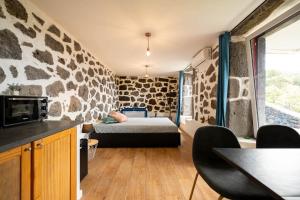 a room with a bed and a stone wall at Liiiving in Açores - Casa de Foros in Foros +53 photos