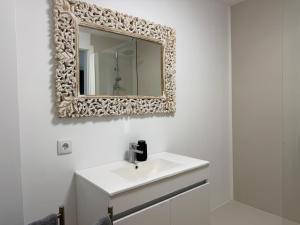 a bathroom with a white sink and a mirror at AZORES PEDRA APARTMENTS - T0 e T1 in Ponta Delgada +36 photos