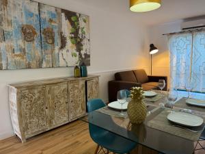 a dining room with a table and chairs and a couch at AZORES PEDRA APARTMENTS - T0 e T1 in Ponta Delgada