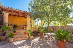 a patio with a table and some potted plants at Ca Na Carme (Alaronera) in Alaró