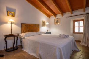 a bedroom with two beds and a table and a window at Ca Na Carme (Alaronera) in Alaró