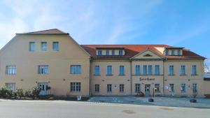 a large tan building with a red roof at Ferienwohnungen Forsthaus in Bad Gottleuba