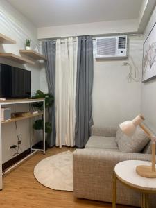 a living room with a couch and a table at 1 Bedroom Arezzo Condotel in Davao City