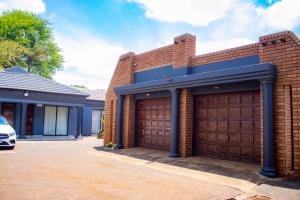 a brick house with two garage doors at Travel Shift Accommodation in Northam