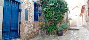 an alley with a blue door and some plants at Casita de Mar in Tossa de Mar