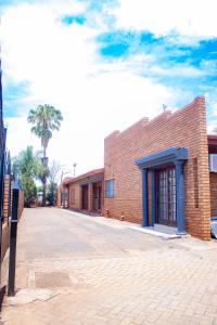 a brick building on a street with a palm tree at Travel Shift Accommodation in Northam