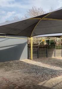 a large black canopy over a brick patio at 26 Rubens apartments in Secunda