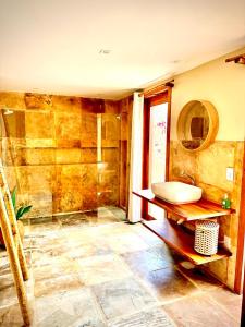a bathroom with a sink and a shower at Chalé Caju Knots in Parajuru