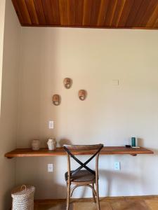 a chair sitting in front of a wall with a shelf at Chalé Caju Knots in Parajuru +59 photos