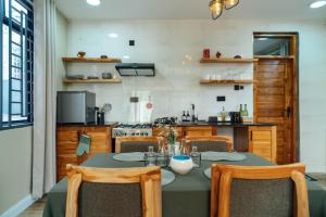 a dining room with a table with chairs and a kitchen at Starico Residence in Nkoanrua