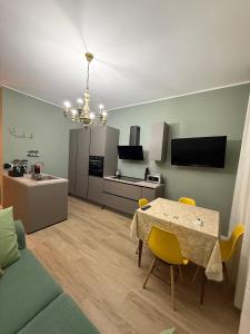 a kitchen and living room with a table and yellow chairs at Brugnoli 13 Guest House in Bologna