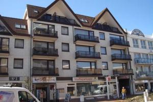 a large apartment building with balconies on a street at Haus Düne, Ferienwohnung 21 in Cuxhaven