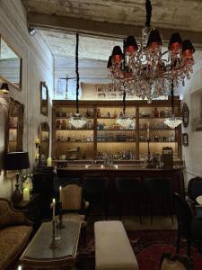 a bar with a table and chairs and a chandelier at Por los Siglos de los Siglos Hotel in Huamantla