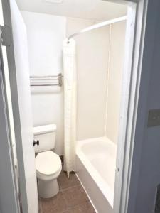 a bathroom with a toilet and a bath tub at Airport Inn in Tulsa