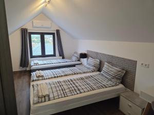two beds in a room with a window at Mini River in Sîngeorgiu de Pădure