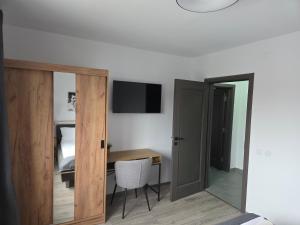 a room with a desk and a bed and a mirror at Mini River in Sîngeorgiu de Pădure