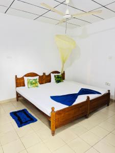 a bedroom with a wooden bed with a ceiling at Moragalla Relax Stay in Beruwala
