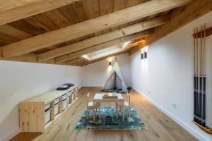 an attic room with wooden ceilings and a table and a play area at Chalet Imperial by Altitudia in Morzine